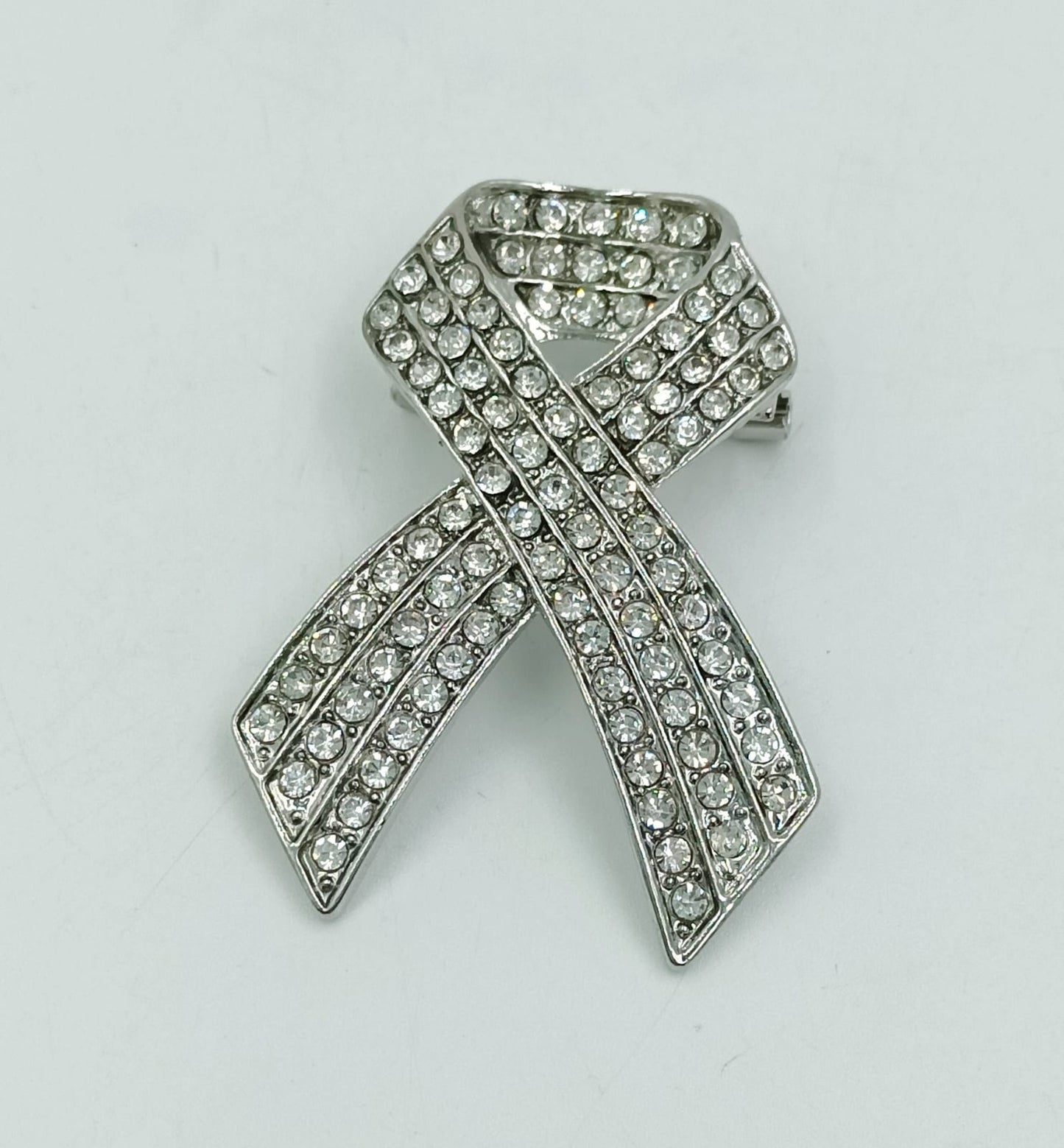 Broche en forma de lazo con piedras brillantes